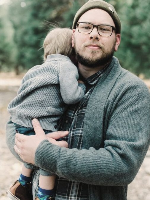 Dad in a beanie holding his son