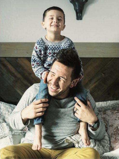 Dad giving his son a shoulder ride at home