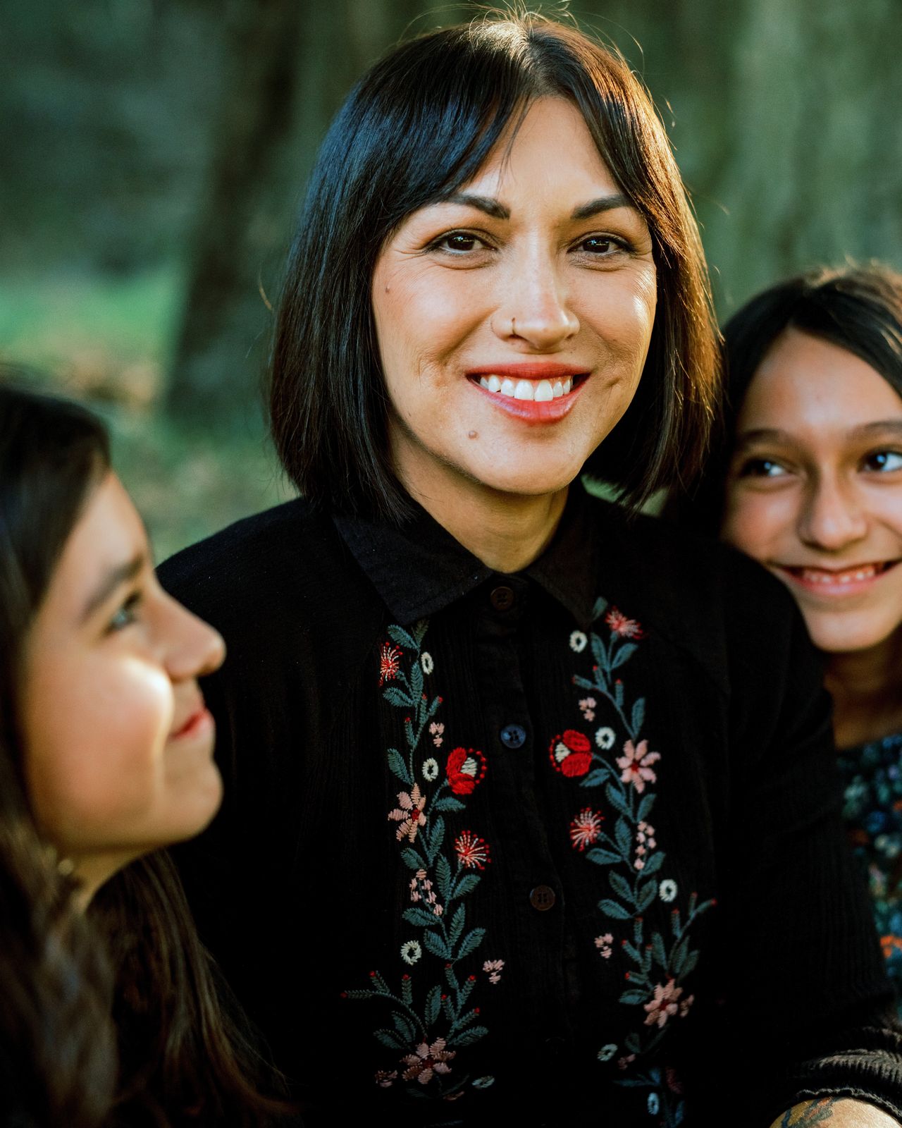 A mother laughing with her two daughters