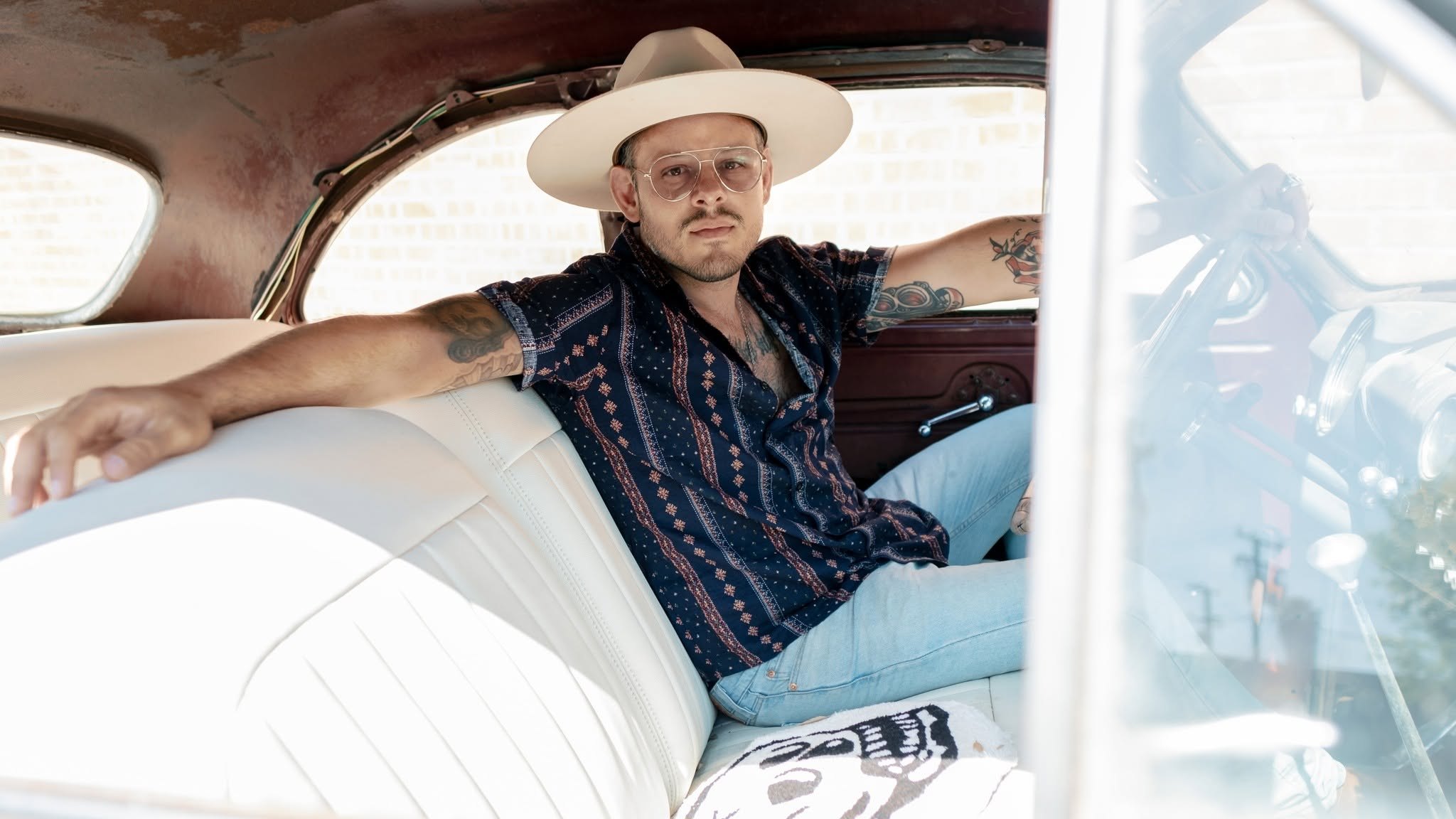 Michael Rochin sitting in the back seat of a vintage car