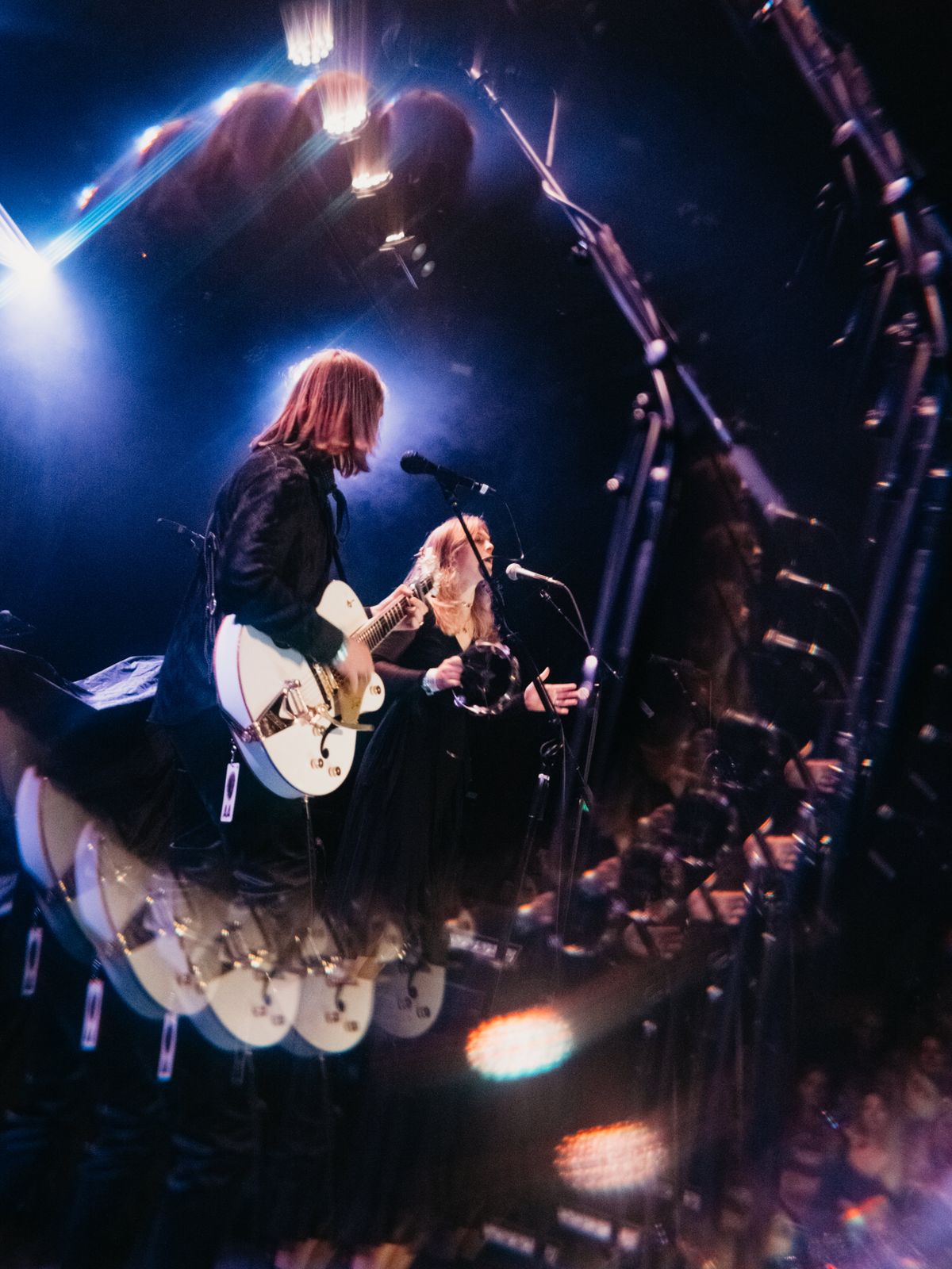 A duo performing in blue stage light seen through a prism