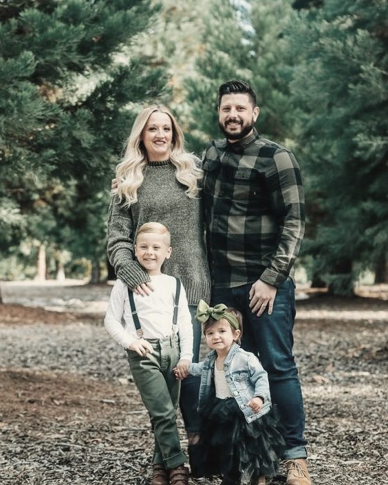 Mom, dad and their son standing in the pines