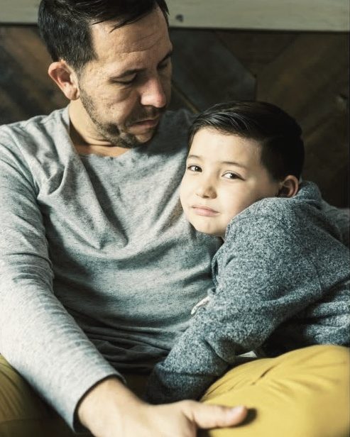 Dad hugging his son at home