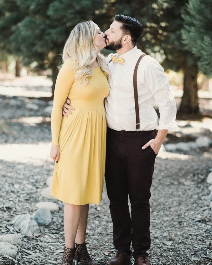 Couple sharing a kiss among the trees